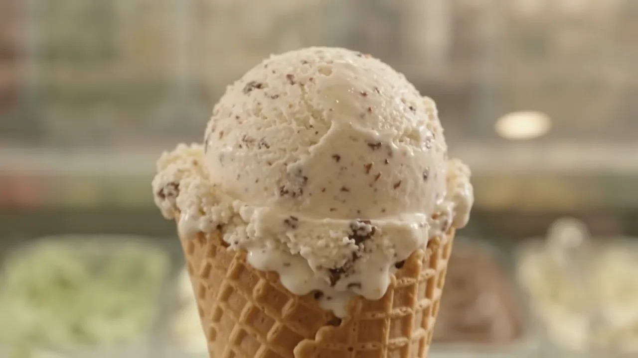 La crema di stracciatella appena mantecata, poi una pallina, poi un cono servito a mano davanti alla vetrina della gelateria